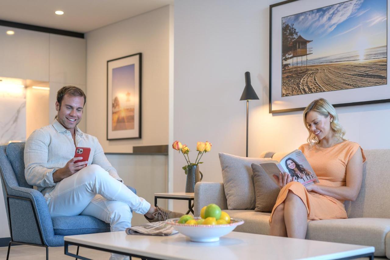 Meriton Suites Surfers Paradise Gold Coast Extérieur photo A couple reading a magazine in their living room